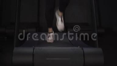 穿白色运动鞋在跑步机上慢跑的女人的腿