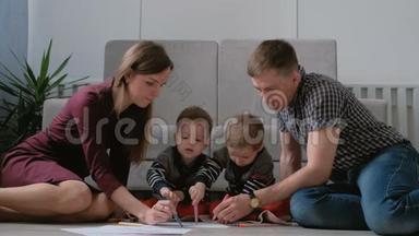 一家人的妈妈、爸爸和两个<strong>双胞胎兄弟</strong>一起画记号，摸着笔坐在地板上。