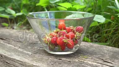 在绿色背景的英国老花园里，用<strong>新鲜</strong>的有机草莓将玻璃碗合上