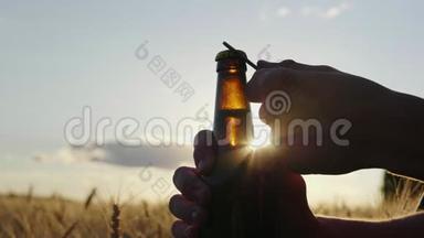 用清凉的啤酒<strong>解渴</strong>. 瓶子的剪影，在日落时在麦场附近打开