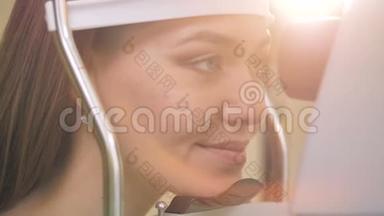 一位妇女在<strong>眼科检查</strong>前把头放在医疗设备支架上。 4K.