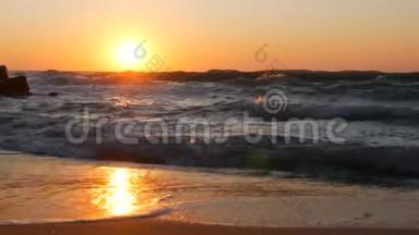 日出或非常美丽的日落在海滨。 沙滩和海浪拍打着海滩。 泡沫大风暴波