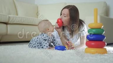 <strong>快</strong>乐的妈妈和<strong>宝宝</strong>在家里地毯上玩玩具。 侧面看一对<strong>快</strong>乐的母子玩玩具