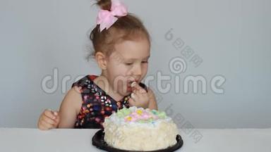 生日快乐。 一个可爱的女孩吃蛋糕，舔她的手指。