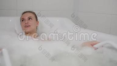 穿着泳衣的快乐女孩在一次放松的水上按摩和慢动作中，用泡沫泡<strong>澡</strong>