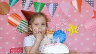 生日和派对蛋糕。 有趣的女孩用甜点舔她的手指。