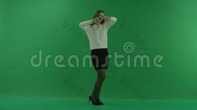 女孩站在一个半转弯的地方，看着灯光，向绿色屏幕上的摄像机伸出大拇指