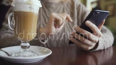 女人在智能手机上使用应用程序，在咖啡馆喝咖啡，在手机上发短信。