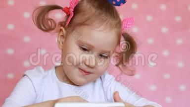 小女孩玩手机。 宝贝在智能手机上使用游戏应用程序。 肖像特写