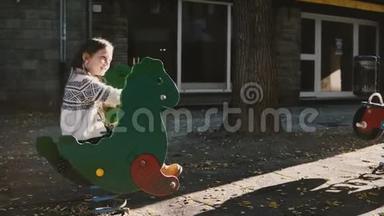 一个骑着绿色恐龙春游的漂亮女孩。 快乐的白人孩子兴奋，和父母交谈。 阳光明媚。 4K.
