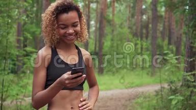 年轻漂亮的美国黑人<strong>卷发女士</strong>在慢跑前用手机聊天