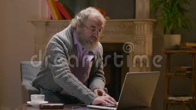 退休人员在笔记本电脑上<strong>一只手</strong>指打字，坐在乡下温暖的小屋里
