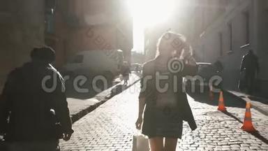 这位穿着漂亮衣服的迷人年轻女孩正在阳光明媚的城市街道上散步，抚摸着她的头发。