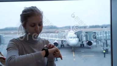 年轻旅游妇女在日程<strong>安排</strong>委员会寻找她的航班状况，并检查机场智能手表的<strong>时间</strong>