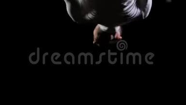 在蹦床上的黑色背景上跳跃体操运动员。 自由和飞行