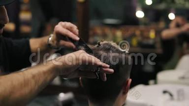 理发师用剪刀`手里拿着一把梳子剪发，他的手在剪发。 慢镜头