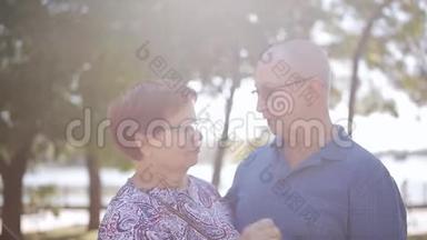 老年、爱情和人的观念-幸福的老年夫妇在户外恋爱。 阳光花园里快乐的老年夫妇。