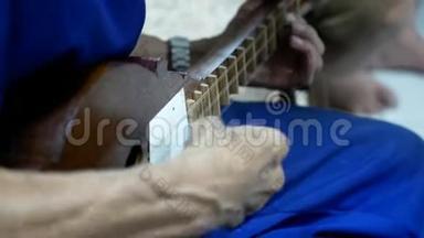 一位演奏Seung的音乐家的手，从泰国北部的兰纳地区摘下<strong>琵琶</strong>，由硬木制成