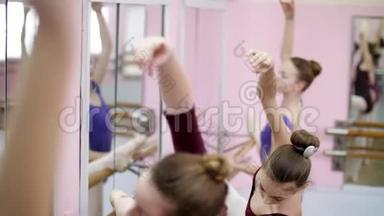 在芭蕾舞厅里，穿着紫色紧身衣的年轻芭蕾舞演员用斜坡表演<strong>胸</strong>罩，优雅地上下移动<strong>双手</strong>