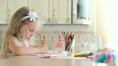 一个可爱的小女孩坐在桌子上，用铅笔画画