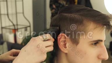 理发店里的男理发师用理发师剪头发。 理发师给男人理发
