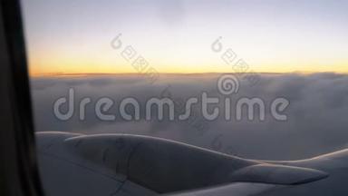 傍晚日落时分，一架客机在云中飞行，从窗外景色。