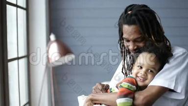 非裔美国父亲拥抱他的小儿子