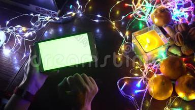 使用智能手机手在黑色背景桌子与彩色灯，圣诞节<strong>新年</strong>作文。 智能手机<strong>游戏</strong>
