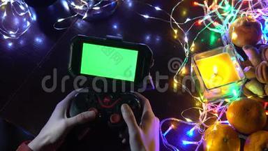 使用手<strong>游戏</strong>垫与智能手机在黑色桌子与彩色灯，圣诞节<strong>新年</strong>作文。 智能手机<strong>游戏</strong>