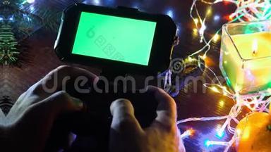 使用手游戏<strong>垫</strong>与智能手机在黑色<strong>桌</strong>子与彩色灯，圣诞节新年作文。 智能手机游戏