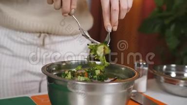 女人在碗碟里拌蔬菜沙拉。 混合素食沙拉的成分。 蔬菜沙拉的准备..