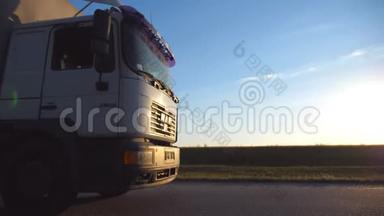 晚上汽车在高速公路上行驶. 阳光落在卡车驾驶室上。 卡车穿过美丽的乡村