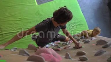 一个年轻的<strong>攀岩</strong>教练教小男孩如何在一个巨石<strong>攀岩</strong>馆里爬墙
