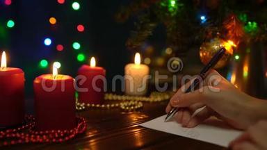 一个女孩在圣诞树、<strong>彩灯</strong>和蜡烛的<strong>背景</strong>上签圣诞贺卡