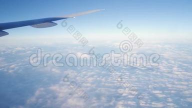 从喷气式飞机的窗户看到云。 飞机在天气上空飞行