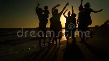 欢<strong>乐</strong>的人群在海滩上跳舞。 他们在阳光下跳跃。 人们玩得很<strong>开心</strong>。 他们很<strong>开心</strong>。 人的剪影