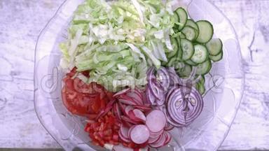 新鲜切碎的夏沙拉。 许多美味的蔬菜在玻璃沙拉碗-黄瓜，生菜，萝卜，西红柿，红葱