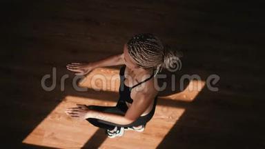 一位身材苗条的年轻金发女子在健身房从事健美操操。 她在健身场所跑步