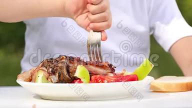 白色盘子的特写与什什烤肉串，烧烤。 这孩子正在吃什什烤串，在特写的自然。