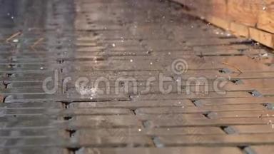雨点落在水坑里。 视频特写雨在人行道上。 城市里的生活。