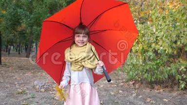 <strong>女孩子</strong>在公园的红伞下散步，秋天，手里拿着黄叶
