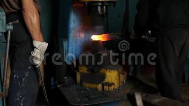 铁匠铺里的铁匠用凿子锤、秤、慢动作锻造一块金属热片