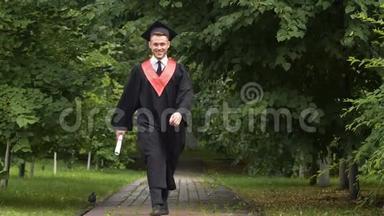 笑容满面的年轻人，穿着学院服，手里拿着毕业证书，高兴得跳了起来