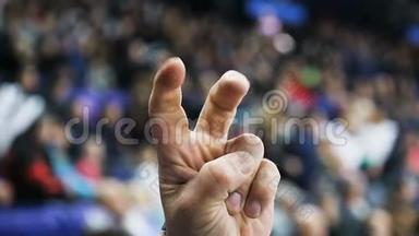 特写体育迷在比赛中用手指显示胜利的象征