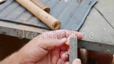 老人用锉刀把软木塞磨成手工长笛，特写