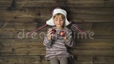 头顶上幸福微笑的女孩子戴着帽子，玩着老式木制背景上的装饰品。 文字或徽标复制空间