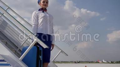 职业空姐在机场的飞机楼梯上挥舞着手提行李