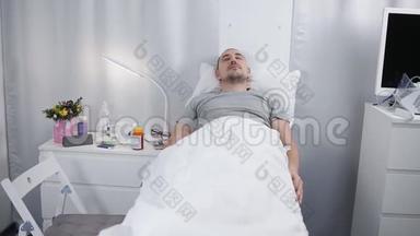 一个男人躺在医院房间的床上。 一个病人正睡在病房的床上。