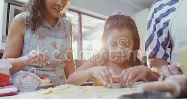 女孩学着和她的母亲和奶奶一起切饼干