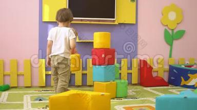 快乐可爱的学龄前儿童在室内操场玩多色软块。 儿童体育活动